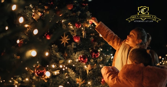 Mother and child decorating Christmas tree at night with lights, Eric C. Cheshire P.A. West Palm Beach family law firm logo.